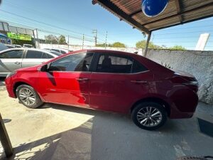 "Toyota Corolla vermelho com design sofisticado, fotografado em ângulo frontal lateral, destacando sua carroceria elegante, faróis modernos e excelente estado de conservação."